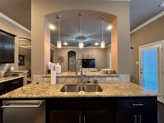 a kitchen with kitchen island granite countertop a sink and cabinets