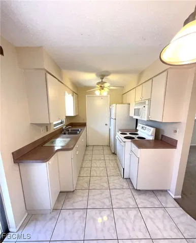a kitchen with granite countertop a sink a counter top space and cabinets