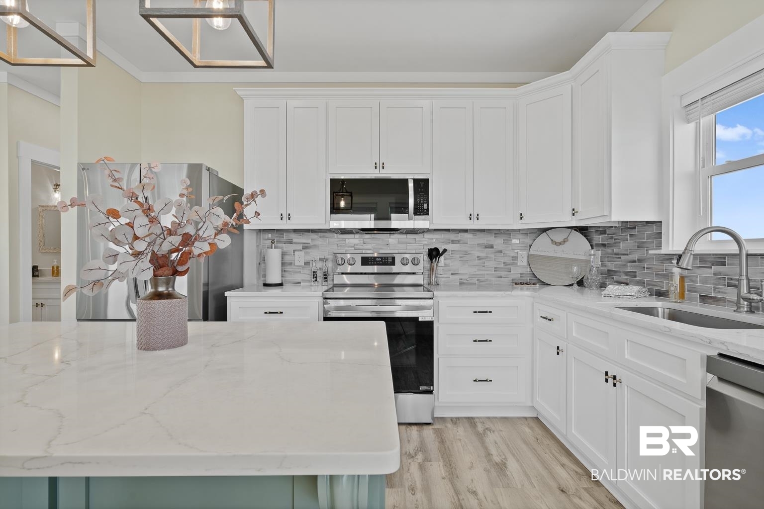 2586 Muscogee Road Gulf Shores, AL 36542 - Photo 9 of 55 Kitchen with light hardwood / wood-style floors, sink, white cabinets, stainless steel appliances, and light stone countertops