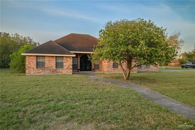 a front view of a house with a garden