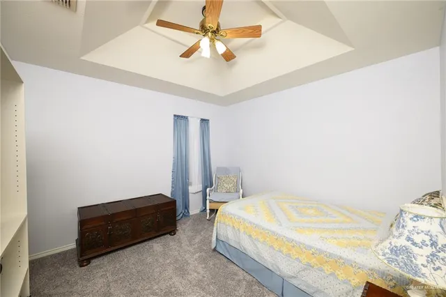 a bedroom with a bed and a chandelier fan