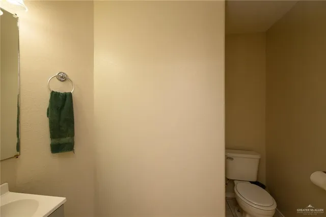 a white toilet sitting next to a white sink and vanity