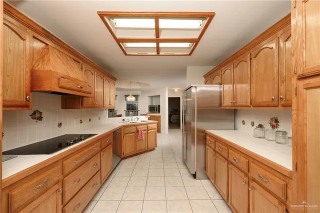 a large kitchen with stainless steel appliances kitchen island granite countertop a sink window and cabinets