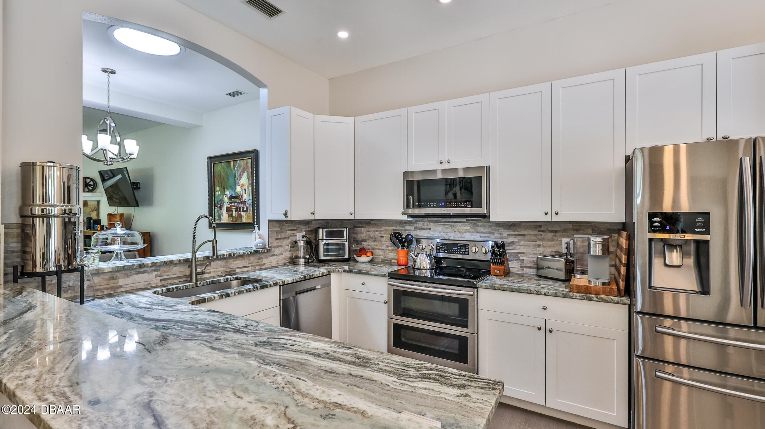 16 Meadow Ridge View Ormond Beach, FL 32174 - Photo 2 of 45 a kitchen with granite countertop a refrigerator stove and microwave