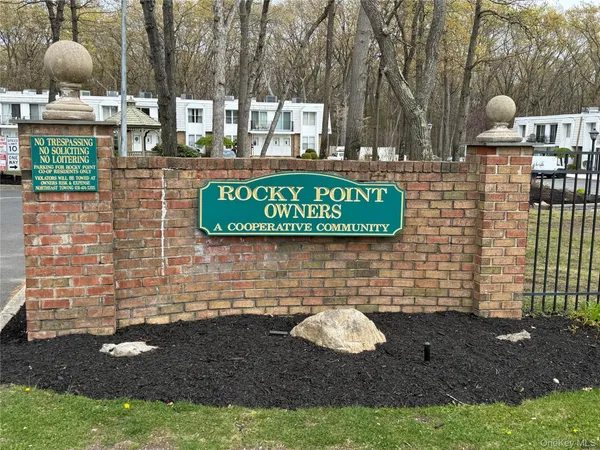 a sign that is sitting on a brick wall