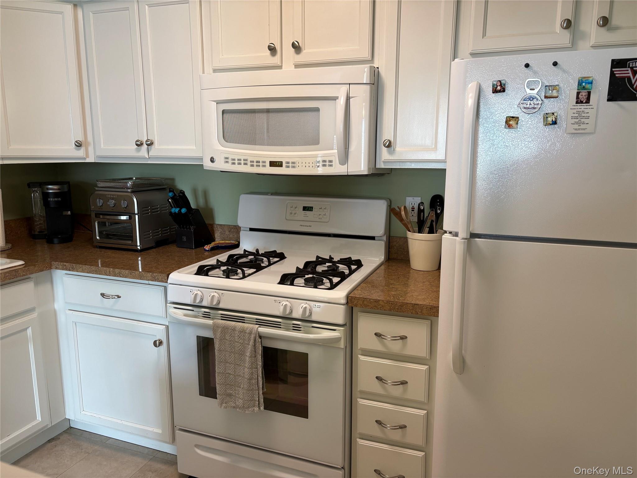 61 Rocky Point Yaphank Road, Unit 61 Rocky Point, NY 11778 - Photo 4 of 12 a kitchen with cabinets and white stainless steel appliances