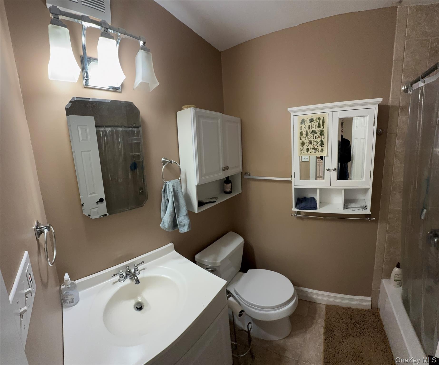 61 Rocky Point Yaphank Road, Unit 61 Rocky Point, NY 11778 - Photo 9 of 12 a bathroom with a sink toilet and mirror