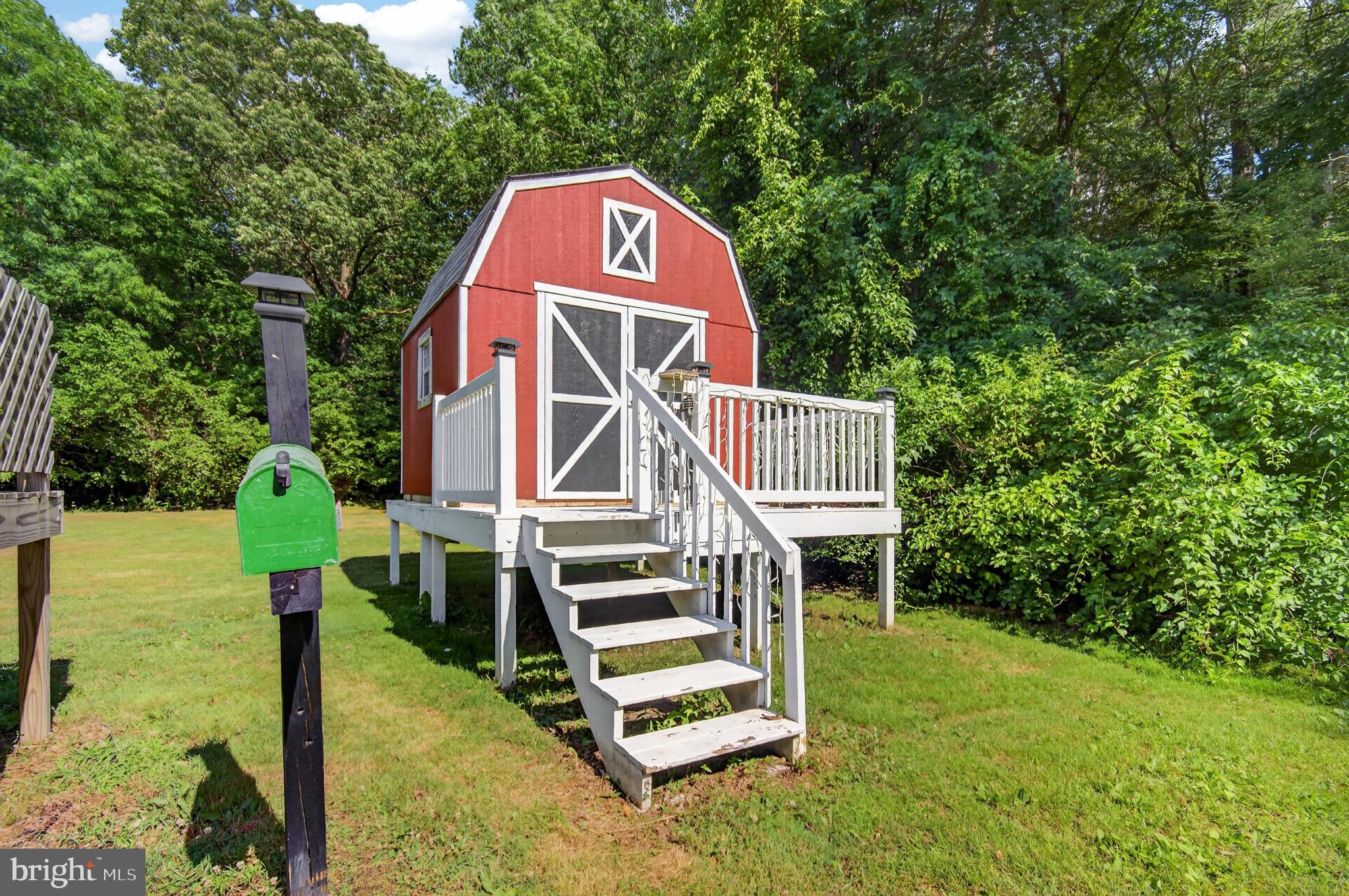 28863 Adkins Road Delmar, MD 21875 - Photo 27 of 29 Charming red shed nestled in greenery.