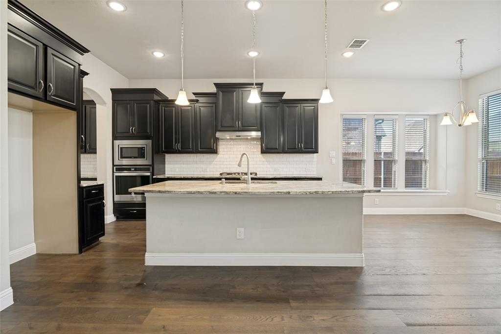 2802 Merlot Circle Rowlett, TX 75088 - Photo 10 of 40 a large kitchen with kitchen island a large counter top stainless steel appliances and cabinets