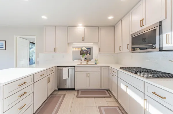 a kitchen with white cabinets and stainless steel appliances