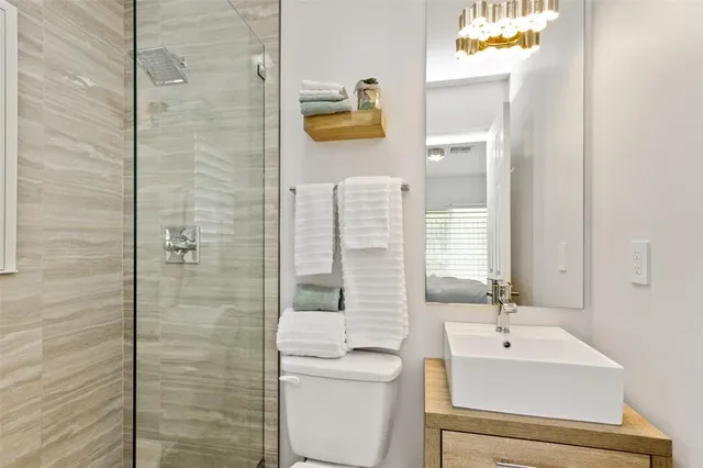 a bathroom with a sink a toilet and shower