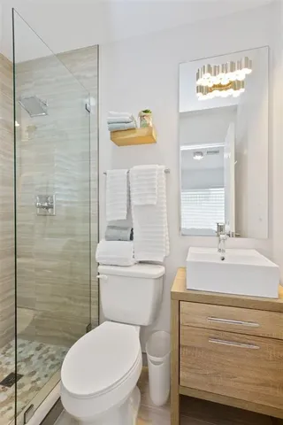 a bathroom with a sink a toilet and shower