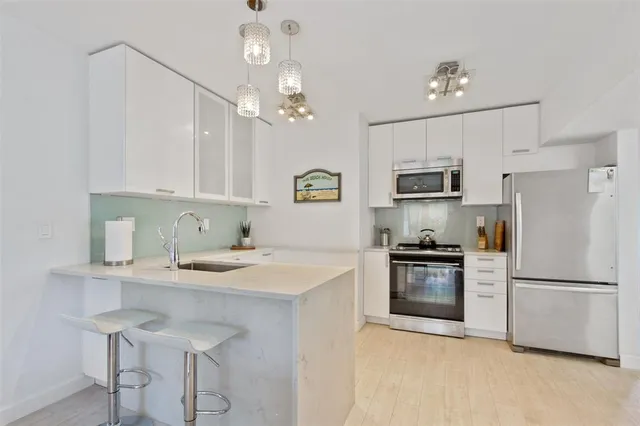 a kitchen with kitchen island granite countertop stainless steel appliances a sink stove and refrigerator