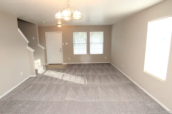 an empty room with windows and ceiling fan