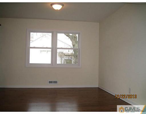 24 Hill Road Edison, NJ 08817 - Photo 4 of 16 an empty room with wooden floor and windows