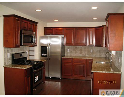 24 Hill Road Edison, NJ 08817 - Photo 5 of 16 a kitchen with granite countertop stainless steel appliances and wooden cabinets