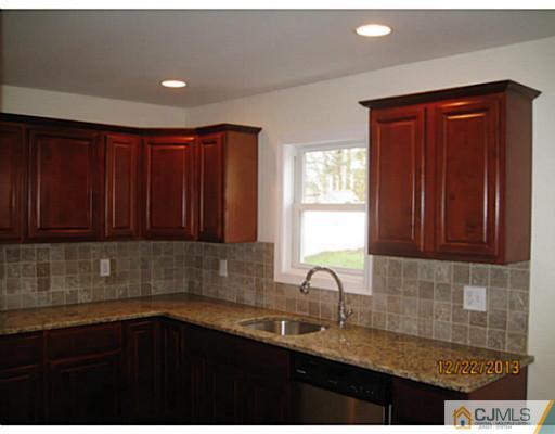 24 Hill Road Edison, NJ 08817 - Photo 6 of 16 a kitchen with granite countertop wooden cabinets a sink and dishwasher