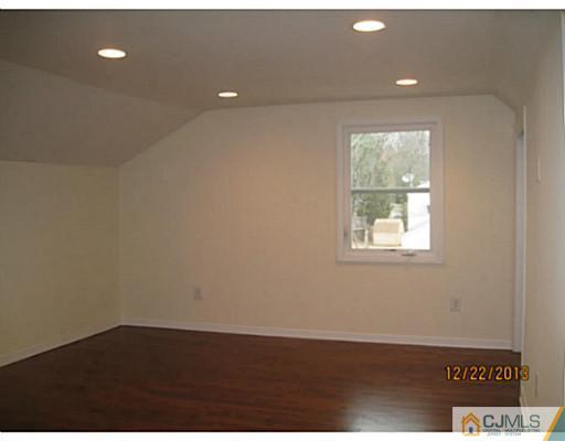 24 Hill Road Edison, NJ 08817 - Photo 9 of 16 an empty room with wooden floor and windows