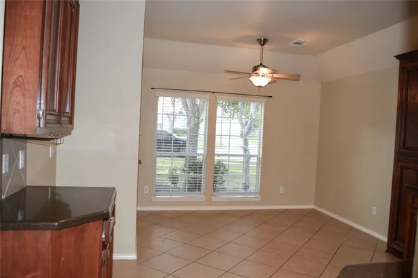 a kitchen with granite countertop white cabinets and a window