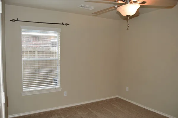 a room with a window and a chandelier fan