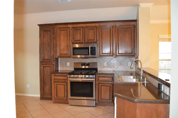 a kitchen with a sink stove and microwave
