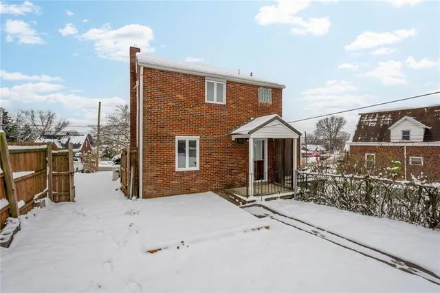 a view of a house with a wooden fence