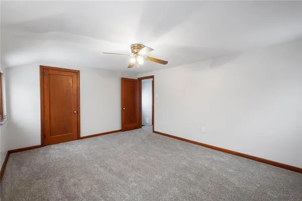 a view of an empty room with a chandelier fan