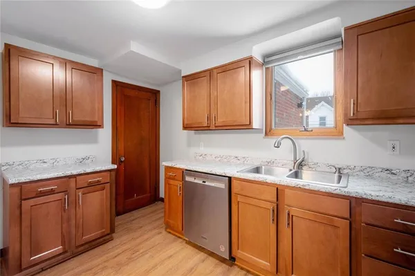 a kitchen with stainless steel appliances granite countertop wooden cabinets and a sink