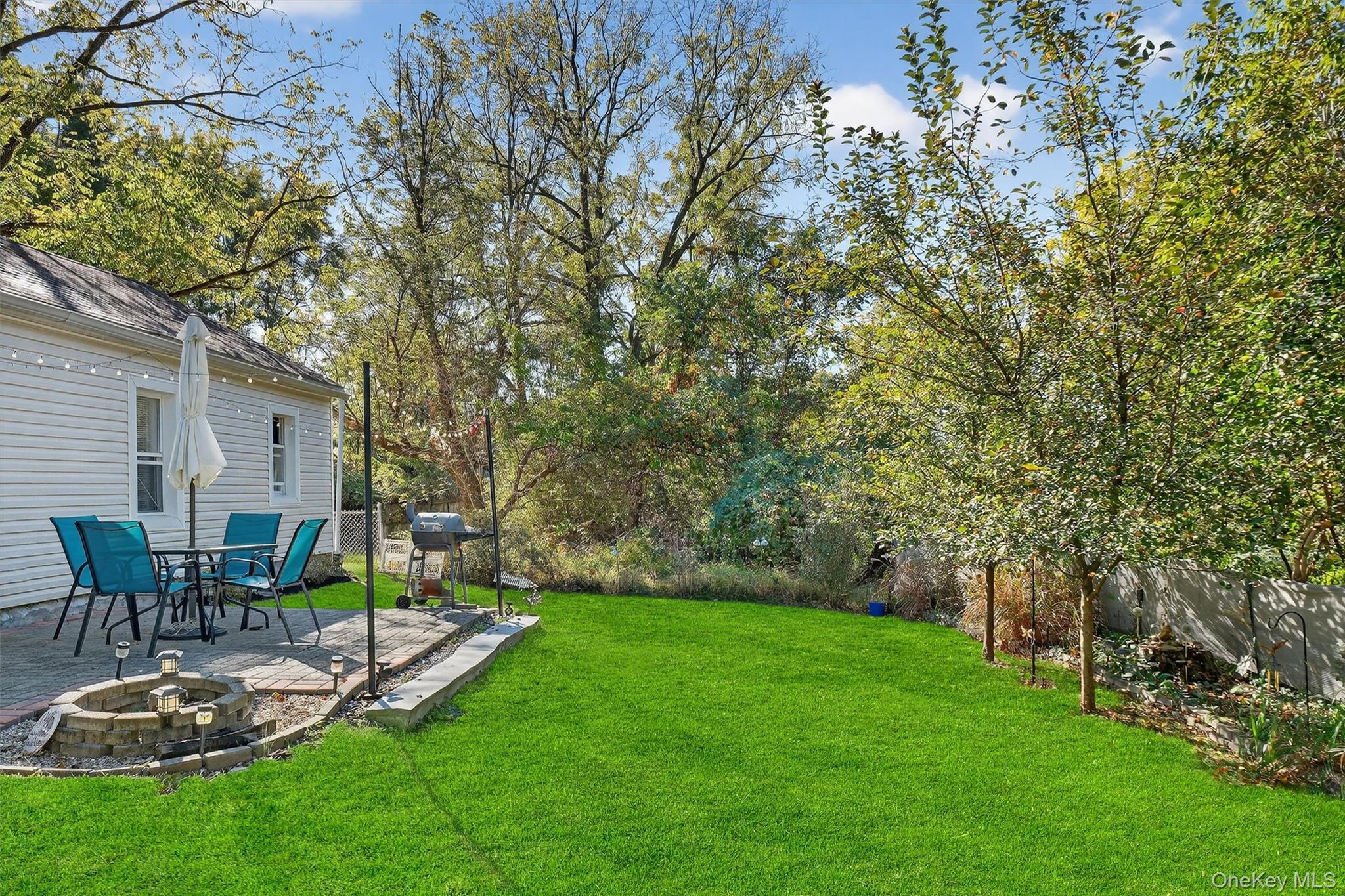 27 Peckham Road Poughkeepsie, NY 12603 - Photo 23 of 27 a view of a backyard with table and chairs potted plants and large tree