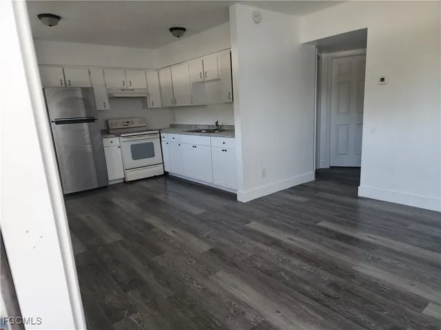 a kitchen with a sink a refrigerator and cabinets