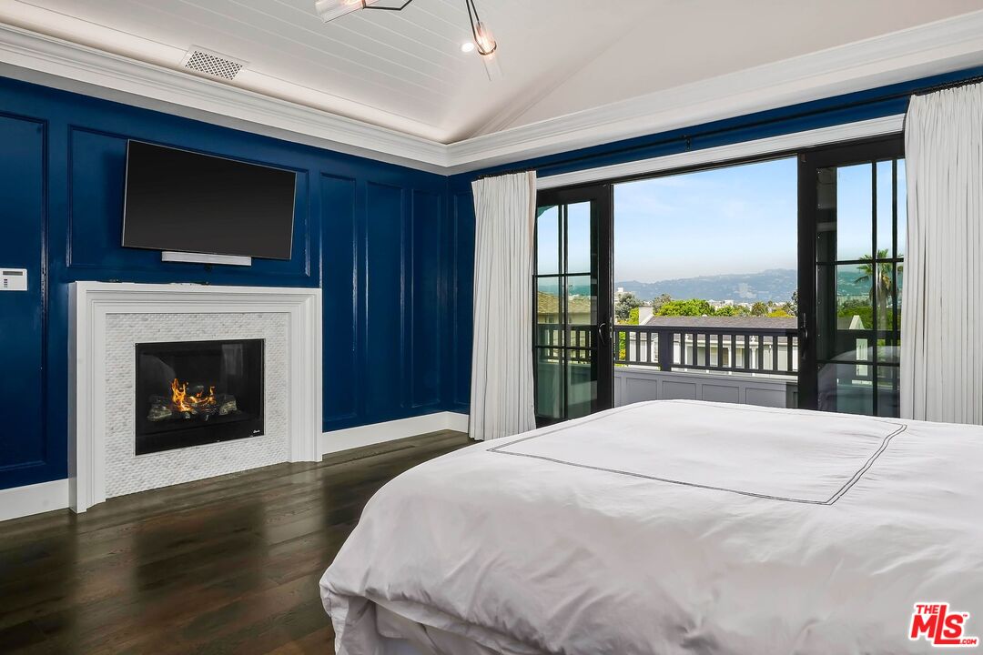 9348 Cresta Drive Los Angeles, CA 90035 - Photo 29 of 44 a bedroom with a large bed and a fireplace