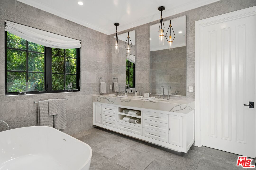 9348 Cresta Drive Los Angeles, CA 90035 - Photo 31 of 44 a bathroom with a granite countertop sink a large mirror and a bathtub