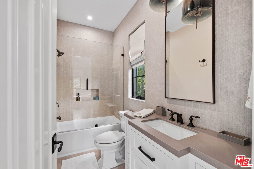 9348 Cresta Drive Los Angeles, CA 90035 - Photo 41 of 44 a bathroom with a granite countertop sink toilet a large mirror and shower