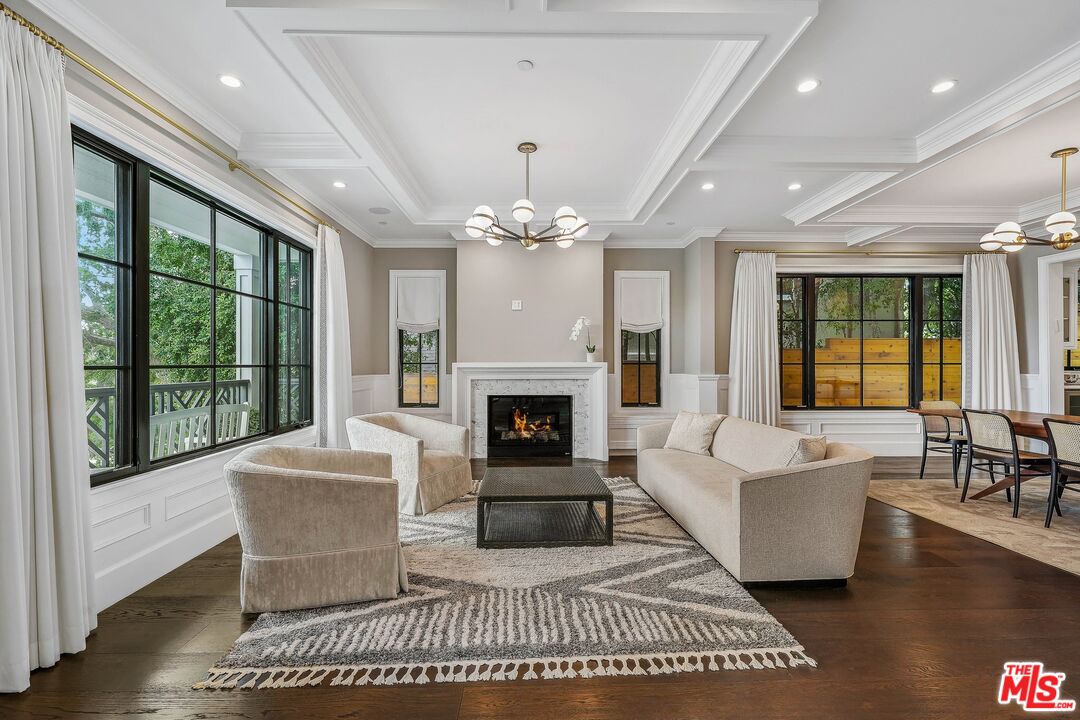 9348 Cresta Drive Los Angeles, CA 90035 - Photo 5 of 44 a living room with furniture a chandelier and a fireplace