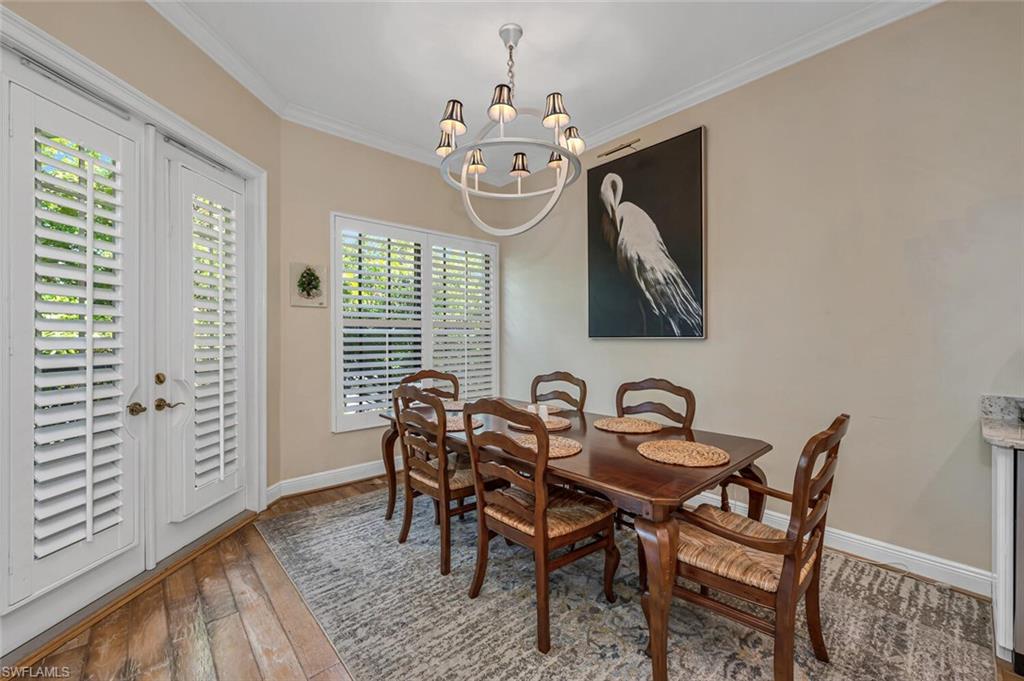 705 10th Street South, Unit 202 Naples, FL 34102 - Photo 4 of 17 a view of a dining room with furniture and chandelier
