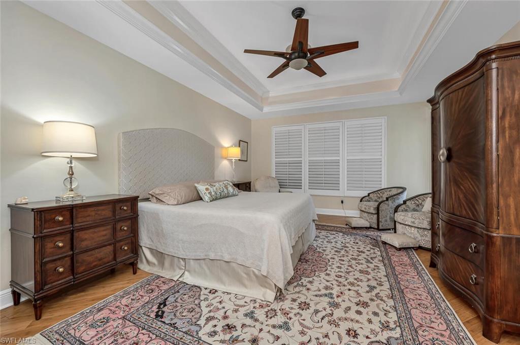 705 10th Street South, Unit 202 Naples, FL 34102 - Photo 8 of 17 a bedroom with a bed a window and a chandelier