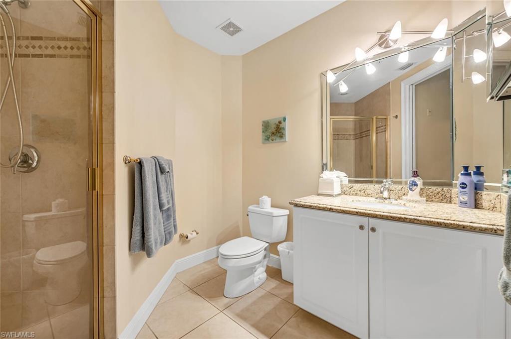 705 10th Street South, Unit 202 Naples, FL 34102 - Photo 10 of 17 a bathroom with a granite countertop sink toilet and shower