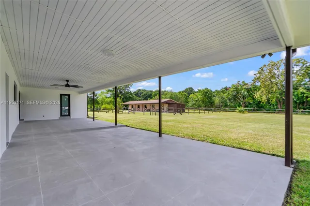 a view of a porch with furniture and a yard