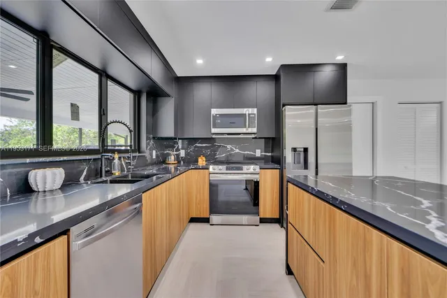 a large kitchen with granite countertop a sink and counter space