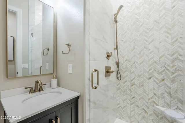 a bathroom with a sink vanity and shower