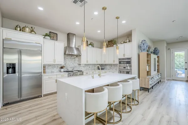 a kitchen with stainless steel appliances kitchen island a refrigerator sink and cabinets