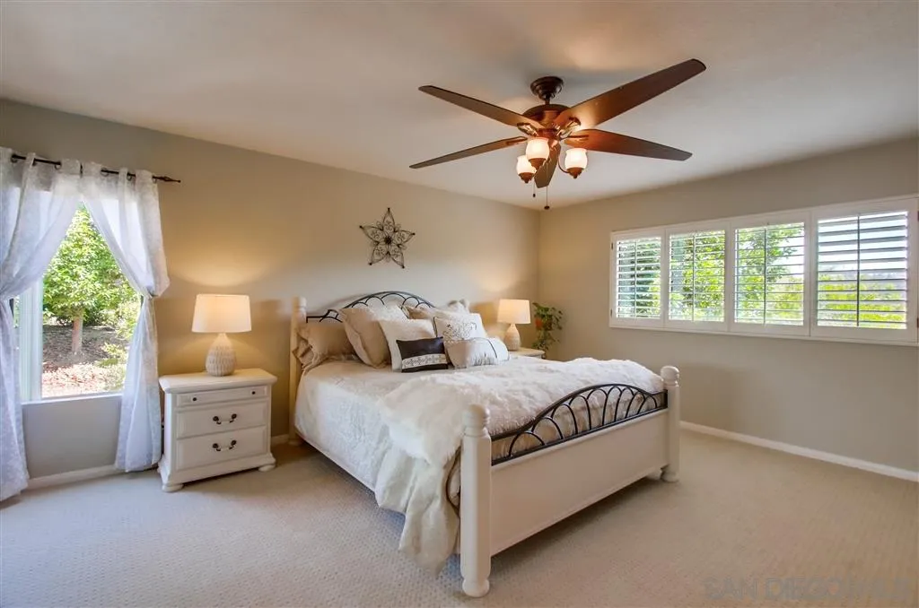 14032 Old Station Road Poway, CA 92064 - Photo 13 of 25 a bedroom with a bed and a chandelier
