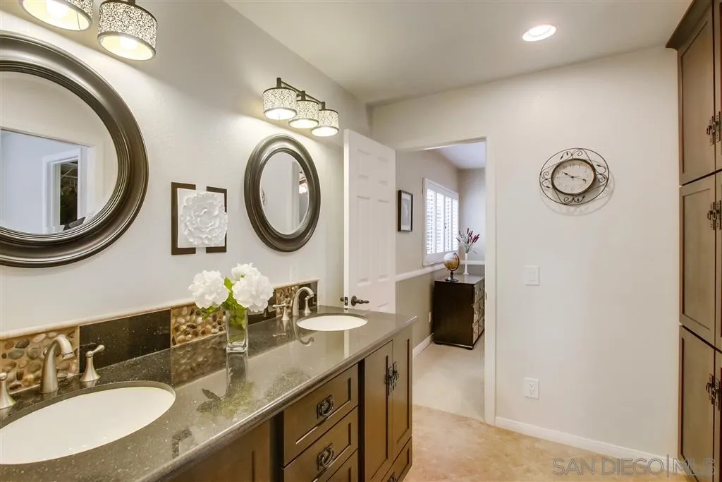 14032 Old Station Road Poway, CA 92064 - Photo 17 of 25 a bathroom with a granite countertop double vanity and a mirror