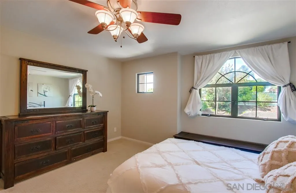 14032 Old Station Road Poway, CA 92064 - Photo 19 of 25 a bedroom with a bed and a chandelier