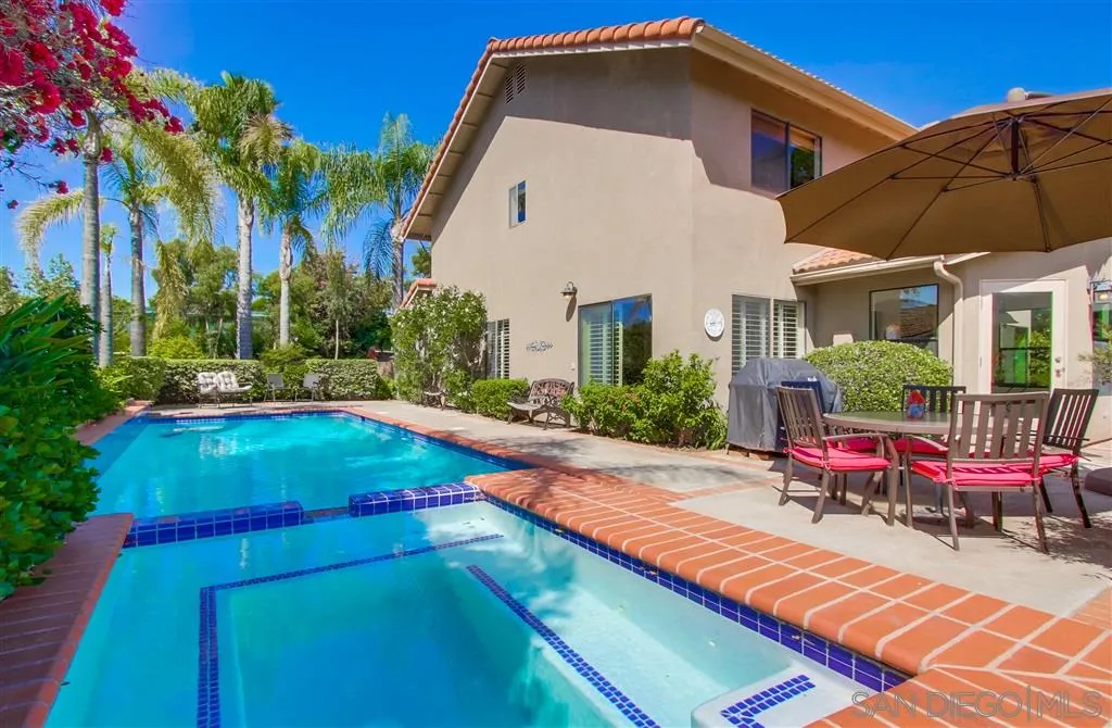 14032 Old Station Road Poway, CA 92064 - Photo 23 of 25 a backyard of a house with table and chairs under an umbrella