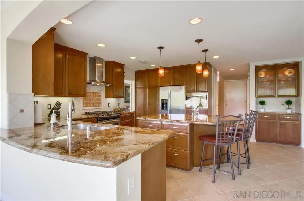 14032 Old Station Road Poway, CA 92064 - Photo 8 of 25 a kitchen with center island table and chairs