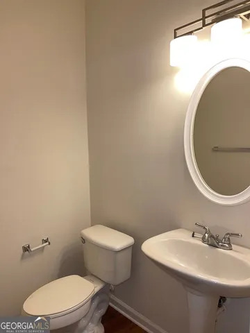 a bathroom with a toilet a sink and mirror
