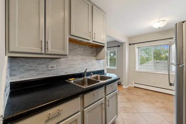 a kitchen with granite countertop white cabinets and black appliances
