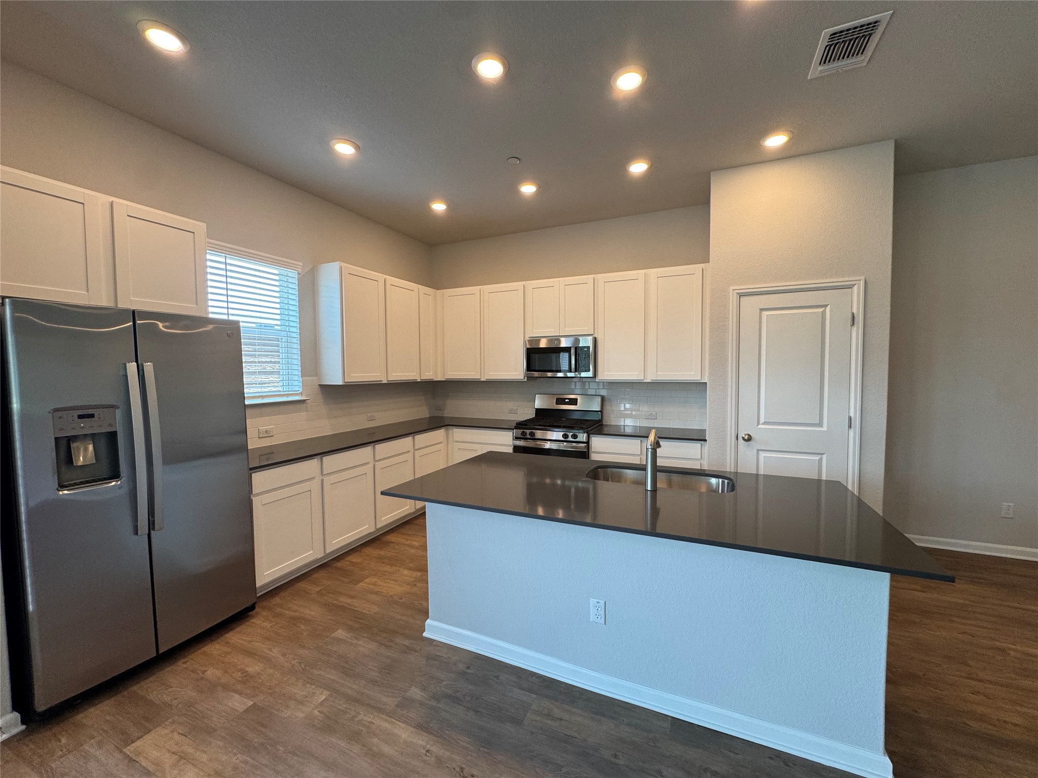 3000 Chisholm Trail Road, Unit 41 Round Rock, TX 78681 - Photo 5 of 28 Culinary adventures await in this naturally illuminated kitchen, featuring abundant white cabinetry and a sleek central island.