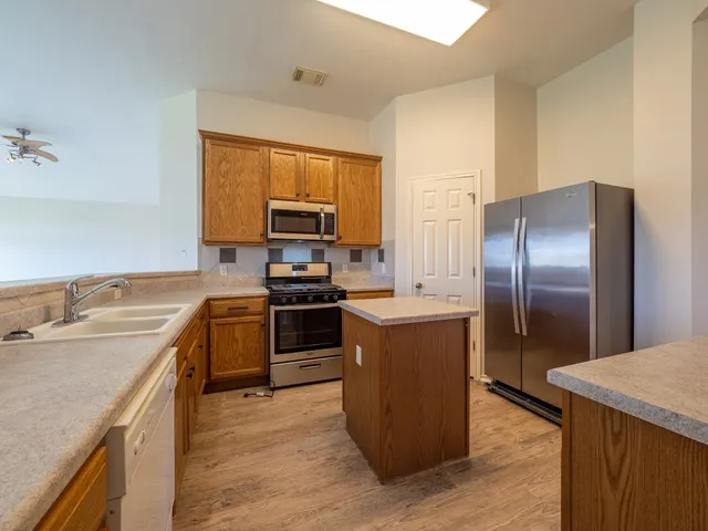 a kitchen with a refrigerator sink and wooden floor